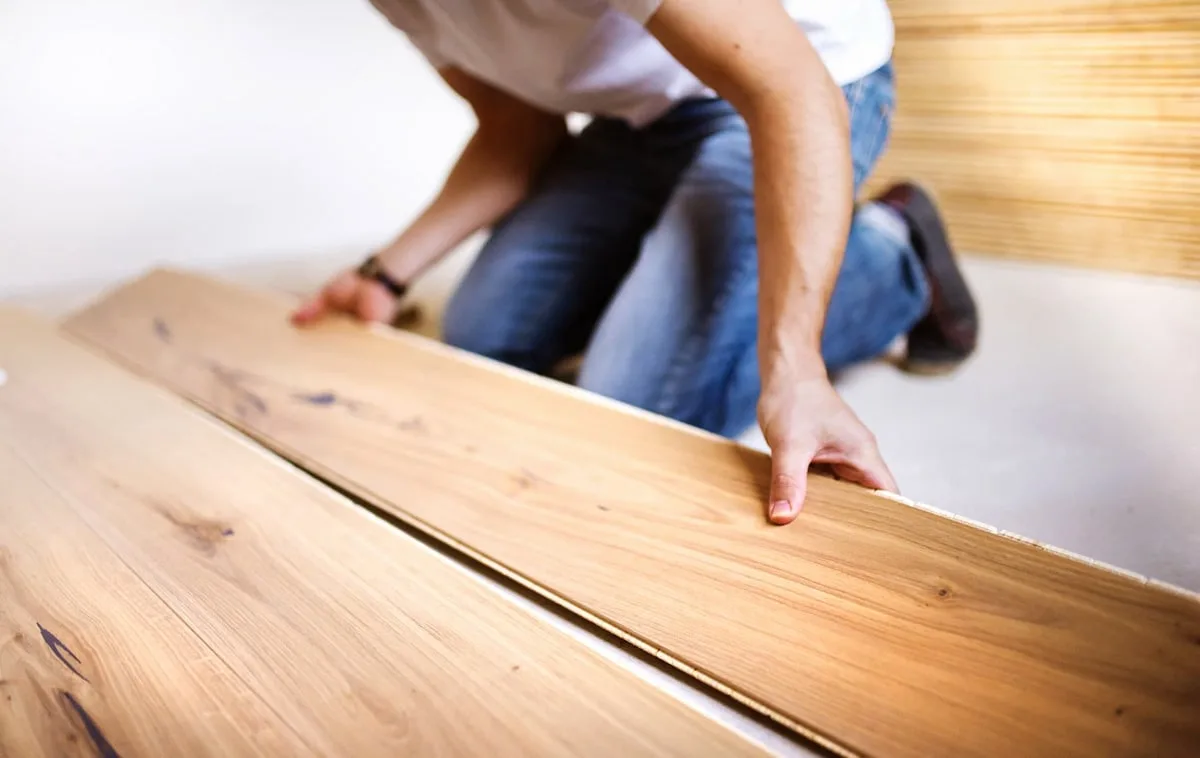 Installer laying hardwood flooring planks